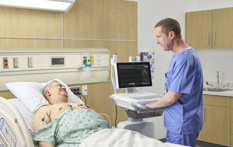 Pfleger legt am Patientenbett die Elektroden an, der MAC VU360 zeigt den Hookup Advisor