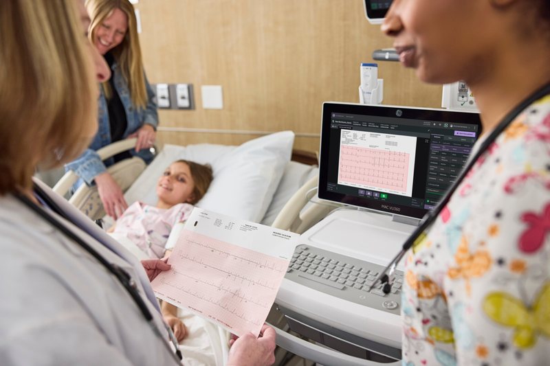 Ärztinnen besprechen ein EKG am MAC VU360 neben dem Patientenbett