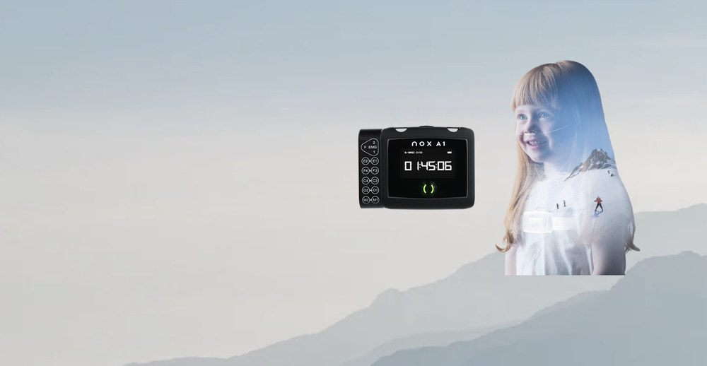 Schlafmessgerät Nox A1 und Kind in einer Berglandschaft