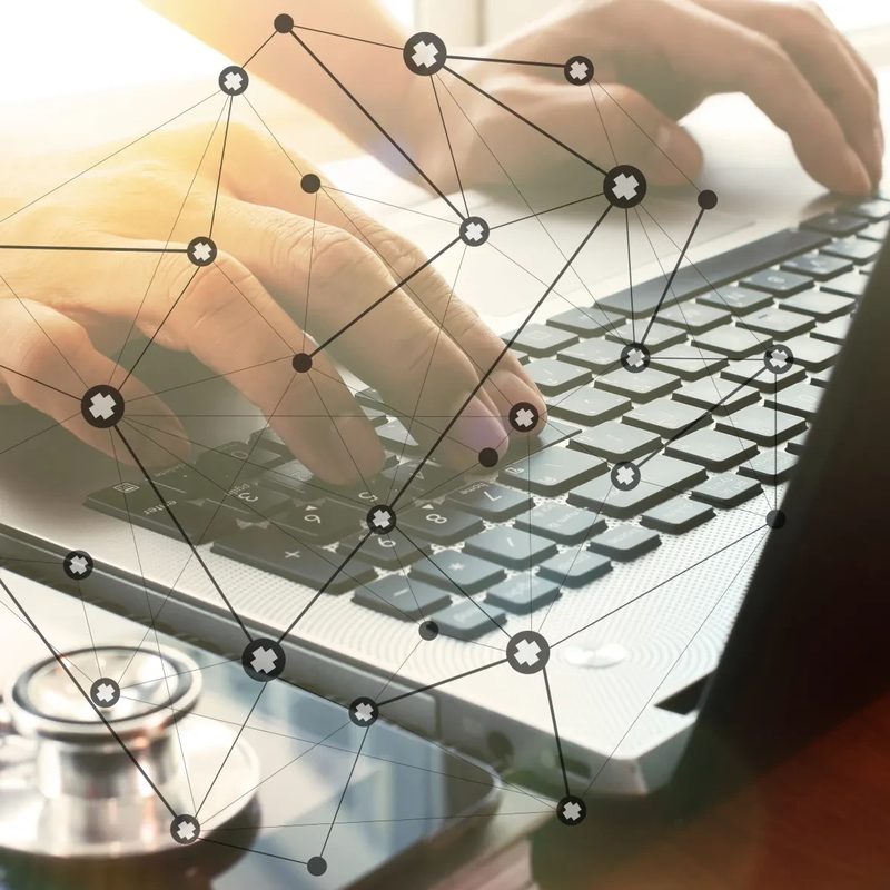 Hände an einem Laptop mit angedeuteter Netzwerkverbindung